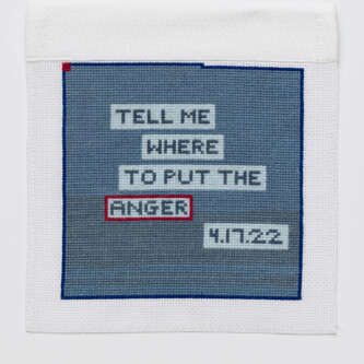 Photo by West Magyar (es translation) Blue stitching on a white square, with the words "TELL ME WHERE TO PUT THE ANGER" inside lighter blue boxes. "4/17/22" is in the lowest light blue box. The box around "ANGER" is outlined in red.